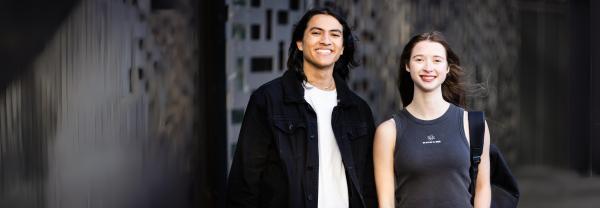 Two smiling students standing outside UTS building 11