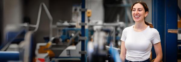 A smiling woman standing in a mechanical lab