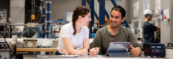 Two mechanical engineer students sitting in a classroom. 