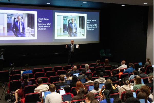 A man speaks to an auditorium