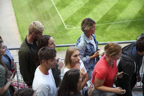 People standing in the stands of a sports stadium. 