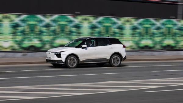 White EV car in motion on streets, front side view