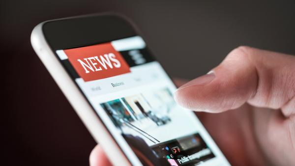 Man reading online news on website with mobile