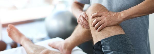 Athlete receiving physio on his knee