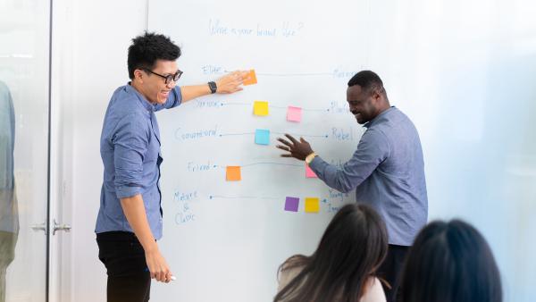 Students brainstorming ideas together on whiteboard