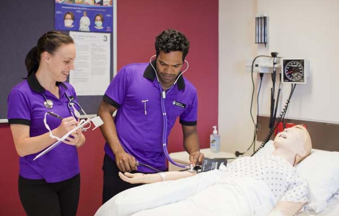 Students using a sphygmomanometer and stethoscope