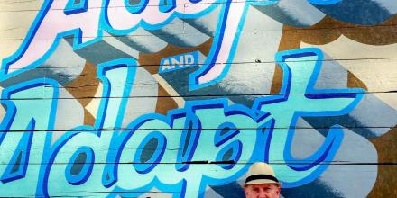 Dr Brent Jacobs standing in front of 'Adopt and Adapt' artwork (photo supplied by Brent Jacobs)