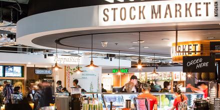 A busy takeaway counter with wood paneling and low hanging lights