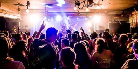 A group of young people dancing at an indoor gig 