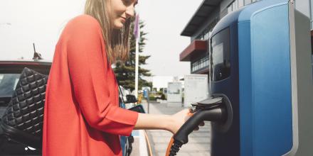 Woman charging electric vehicle