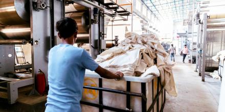 Textile, Industry, India - A Factory Worker Pushing to the Fabric Dyeing Machine