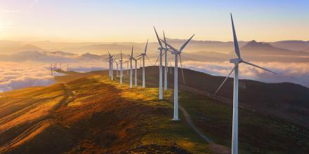 Wind farm on top of a hill at sunset