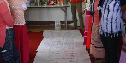 Women talking and looking at hand drawn chart along the floor