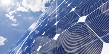 Solar panels shot from below with clouds and blue sky