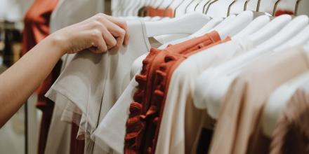 hands looking through a rack of clothes