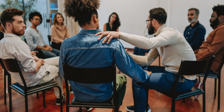 A group of people sitting in a circle facing each other and making conversation.