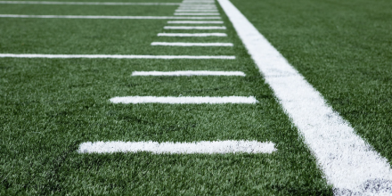 Close up shot of a sports field with white grid iron lines painted