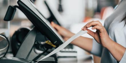 Women pulling a receipt out of a machine