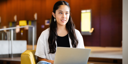 Female IT student on laptop studying in building 11