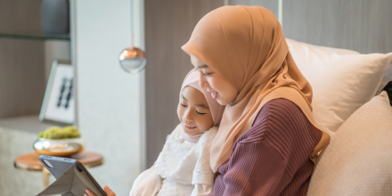 Muslim mother and daughter looking at a tablet