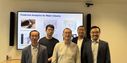 The UTS Smart Infrastructure Team stand in front of a projector in a meeting room. 