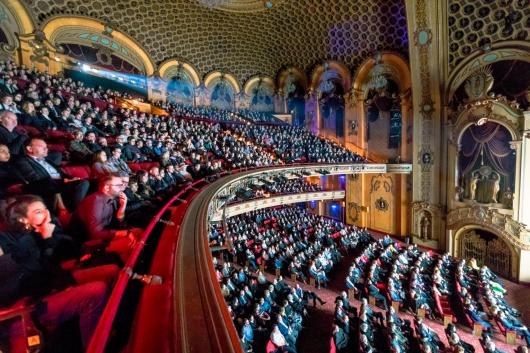 An audience sitting in a regal looking concert hall