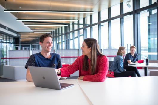 two students sitting in front of a computer