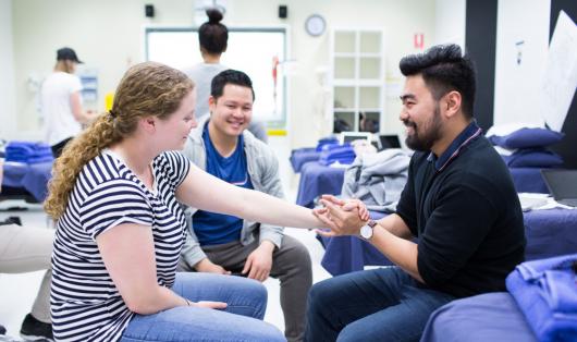 Student practicing physiotherapy skills on a students arm