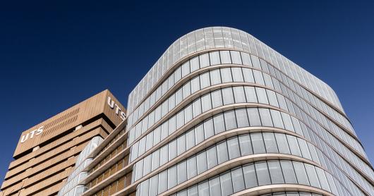 The brutalist square cement UTS Tower stands alongside the curved, glass-encased UTS Central