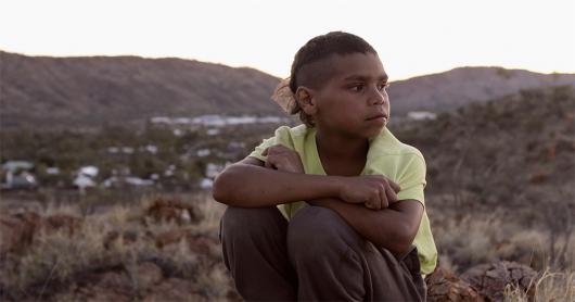 Dujuan Hoosan sitting on a hill against the backdrop of his hometown 
