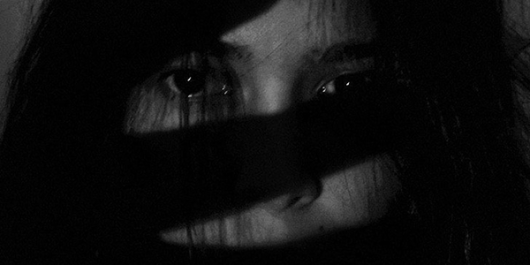 Shadow of a hand over a woman's face.