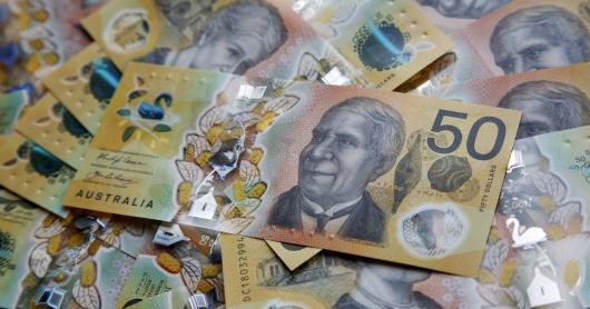 a pile of Australian bank notes with a $50 note on the top