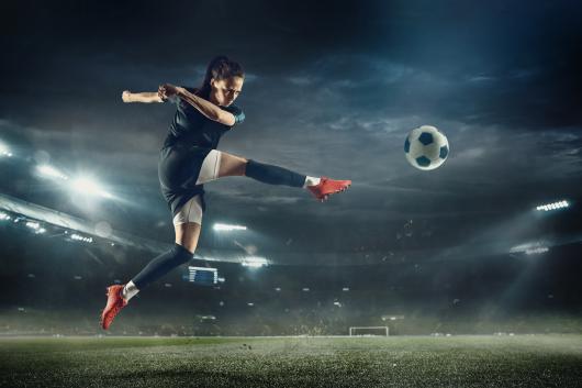 woman kicks a soccer ball