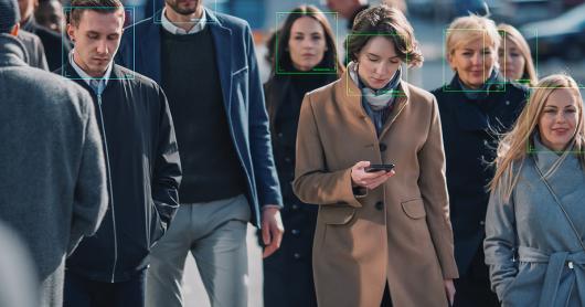 a crowd walking, facial recognition boxes superimposed on faces