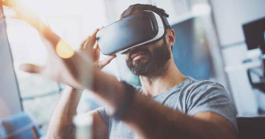 Close up of young man using a virtual reality head set.