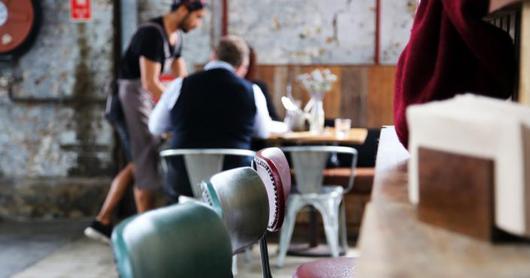 Empty cafe chairs with customers being served in the background