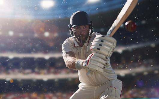 Stock image of a cricket batsman with a stadium crowd in the background 