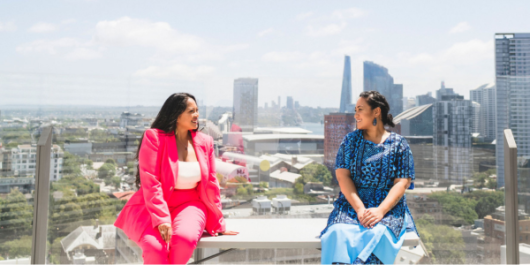 Leah Subijano and Christine Afoa in front of a city skyline