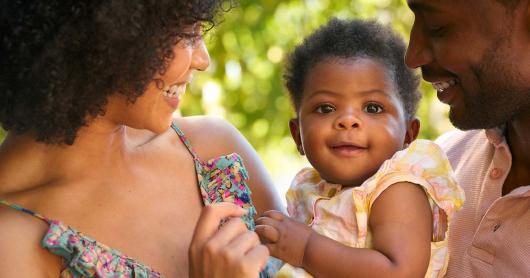 two parents look lovingly at a baby