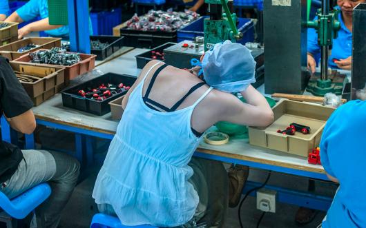 Migrant workers on the assembly line making toys in Dongguan, Guandong. 2015. Photo: Zhan Youbing, CC BY 4.0