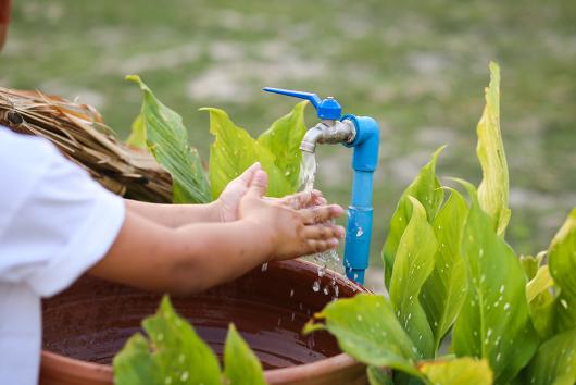 Child washing their hands under a tap