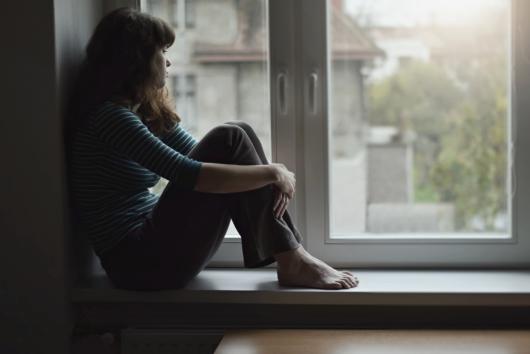 Woman by window in lockdown. Adobe Stock By Tunatura