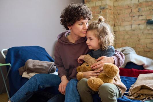 Woman hugs child. Adobe Stock 