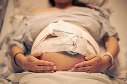 Stock picture of a pregnat woman in hispital with sensors placed to monitor fetal heartbeat