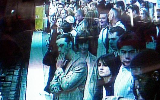 A group of people on a train station pictured on a security screen. Picture by marcokalmann on Flickr, CC BY-NC-ND 2.0