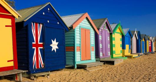 A row of colourful painted shacks on a beach