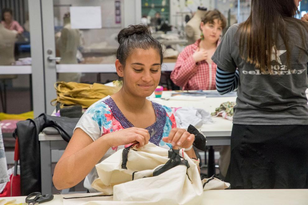 Student cutting fabric, when using the sewing studio