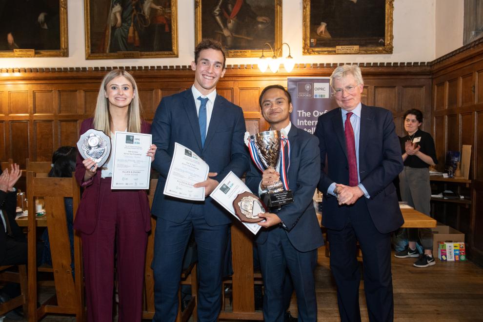 Prize winners holding mooting cup and certificates