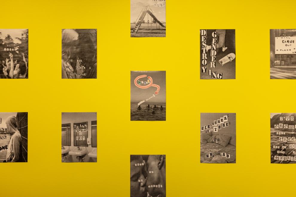 A close up of  black and white collages displayed on a yellow wall 
