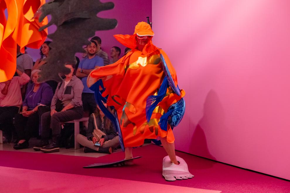 A person in an orange costume poses